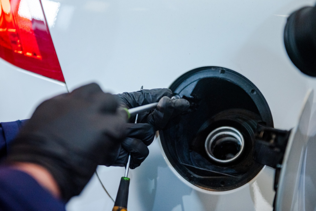 Person loosing the screw on the fuel cap