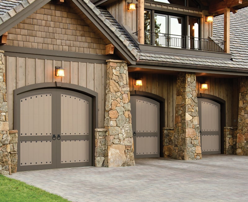 A three door garage with arched doors, clavos, and ring pulls