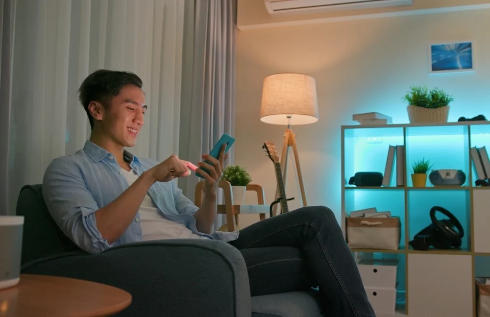 A guy is managing his electronic devices using smart home charging system.