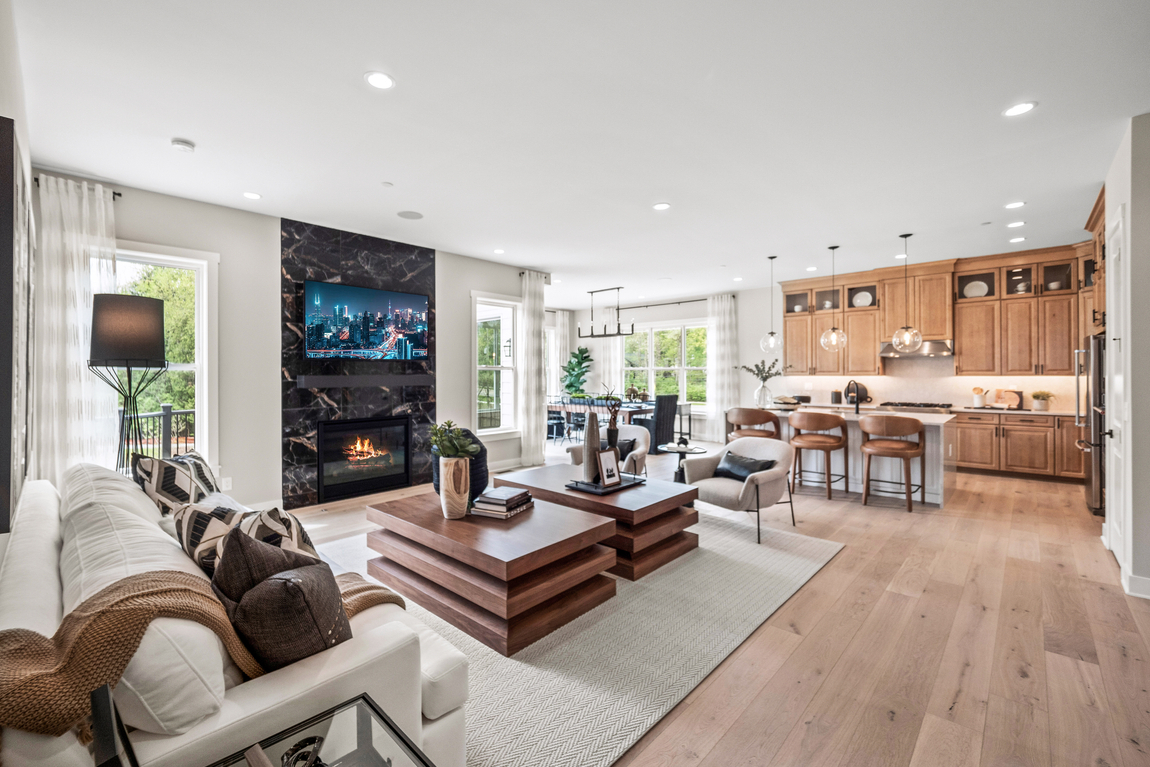 Living room with fireplace and open concept living space into the kitchen.