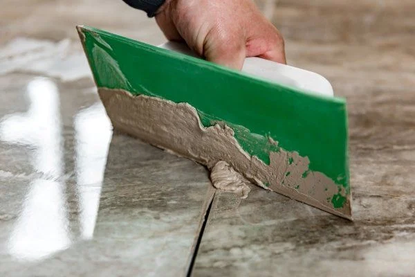 grouting-ceramic-tiles-tilers-filling-space-tiles-using-rubber-trowel