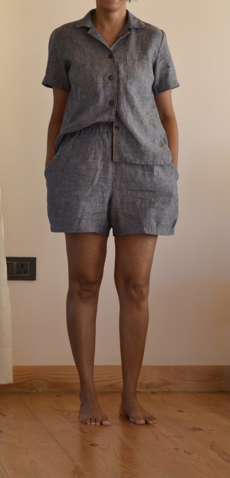 Close up of a woman wearing a button-up pajama shirt and pajama shorts
