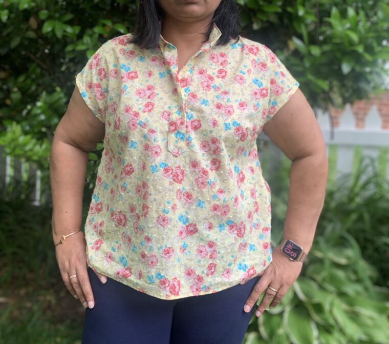 Picture of a woman from the shoulders down wearing a pullover blouse.