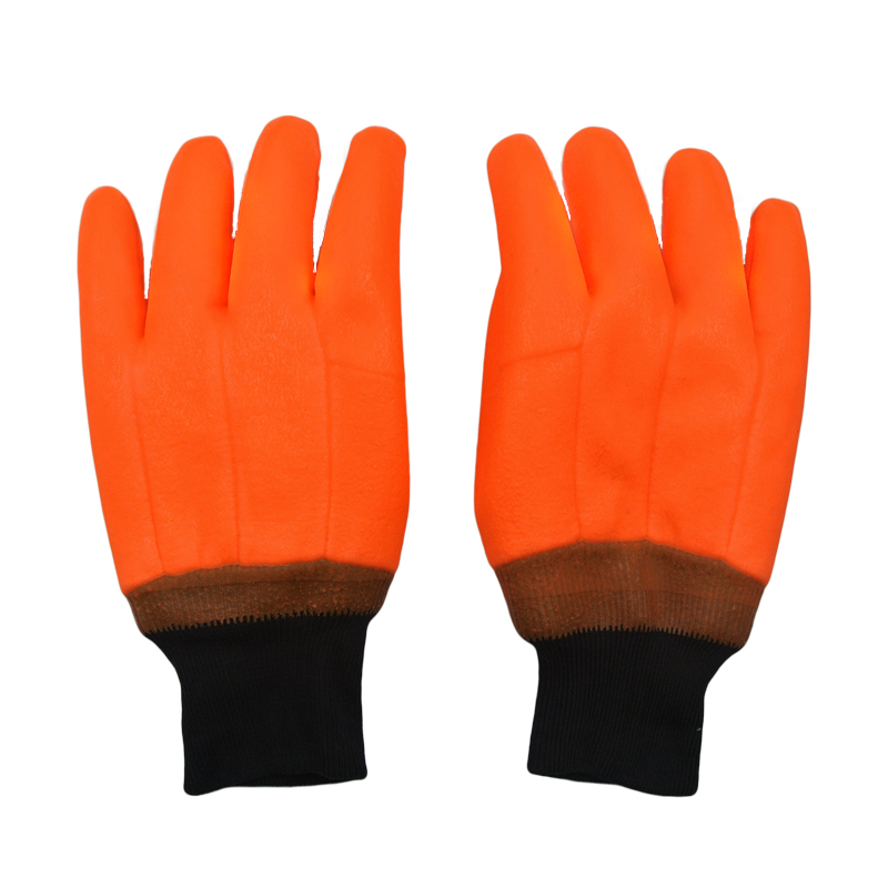 Fluoreszierende orange PVC-beschichtete Handschuhe sandig