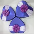 Scatola di latta di cioccolato viola con decorazione floreale