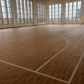Un piso de baloncesto interior de vinilo con apariencia de madera real