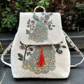 Mochila étnica multifuncional con solapa teñida en hilo y detalle de borlas