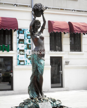 Life size bronze beautiful sexy naked fairy holding on a flower basket to welcom customers sculpture