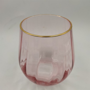 Bordo dorato e fiori in vaso di vetro di colore rosa