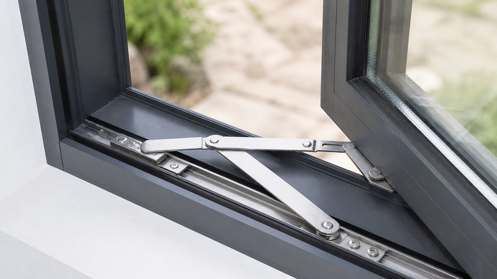 Casement window friction stay hardware detail Close-up of a stainless-steel friction stay fitted to an aluminium casement window