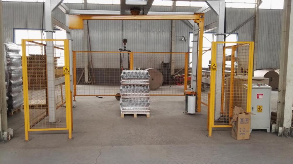 Rotary-arm conveyor pallet wrapper