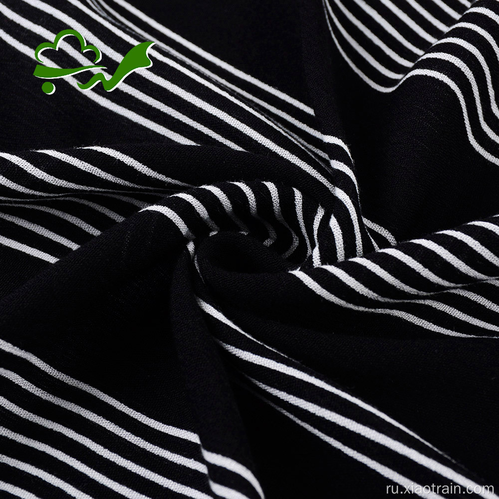 Белая вискозная креповая ткань с черными полосами и принтом
