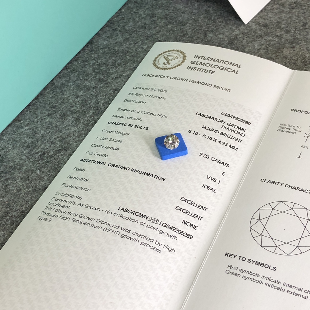 Diamante cultivado en laboratorio, redondo y suelto, apoyado sobre un informe de diamantes cultivados en laboratorio de IGI