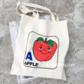 Op maat gemaakte smiley apple canvas tas schuin over het pakket