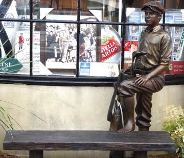 outdoor life size bronze sculpture of a caddy with a bench