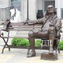 Outdoor bronze franklin sitting on a bench statue for the University