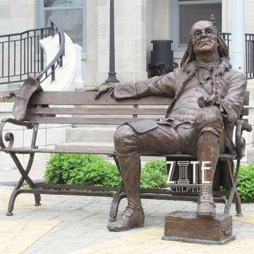 Outdoor bronze franklin sitting on a bench statue for the University
