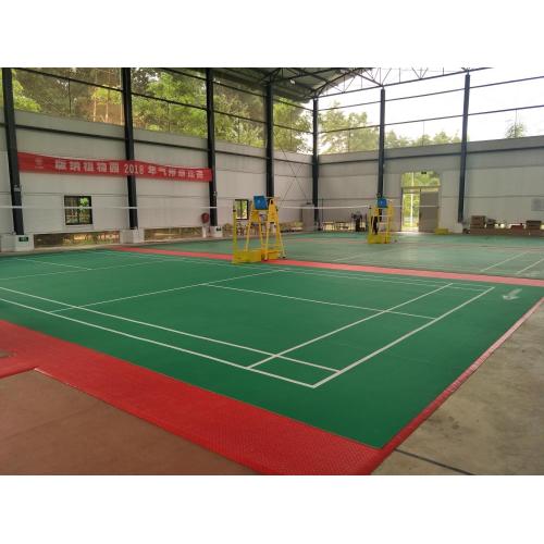 Competencia de bádminton utilizando un piso PVC de patrón de arena subyacente