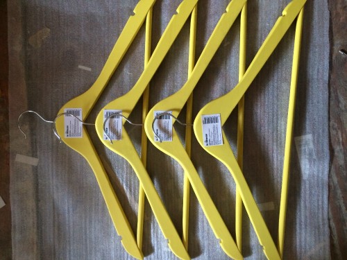 Yellow rubber coated wooden garment hanger with round bar