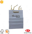 Pequeña bolsa de papel de regalo con mango de oro