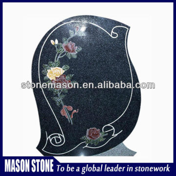 Mosaic gravestone surrounded by flowers