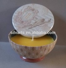soy wax colored candle in metal bowl