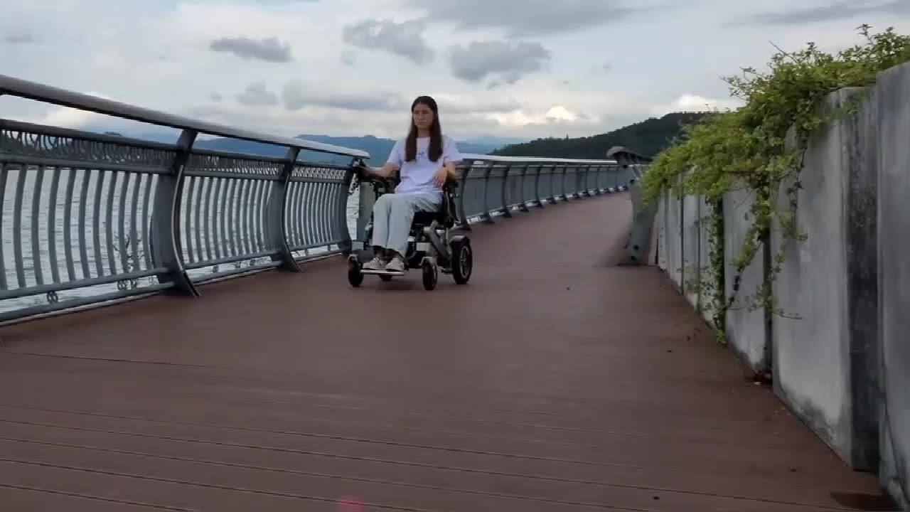 Patient handicapé voyageant sur tout terrain à distance de télécommande en fauteuil roulant électrique