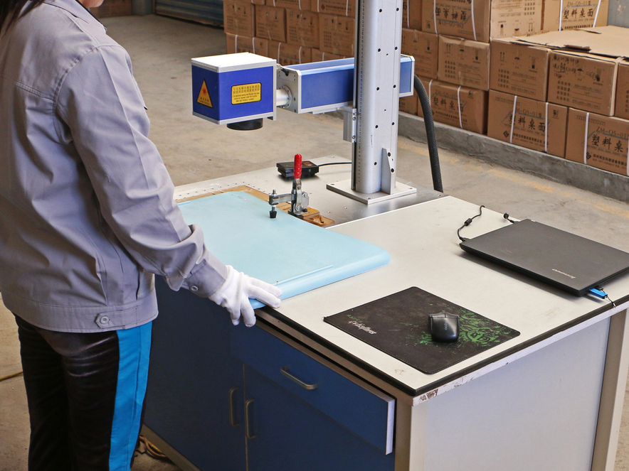 Worker Operating Laser Marking Machine in Factory