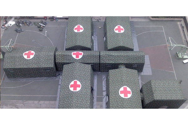 Modular tent deployed in disaster relief application showing field hospital setup