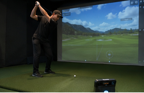 Golfer preparing to hit a shot in an indoor golf simulator