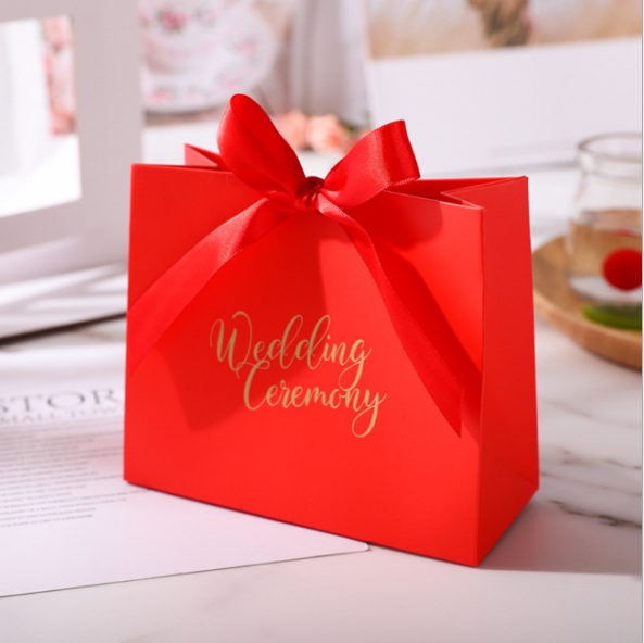 حقيبة ورقة هدية حمراء لحضور حفل زفاف مع الشريط