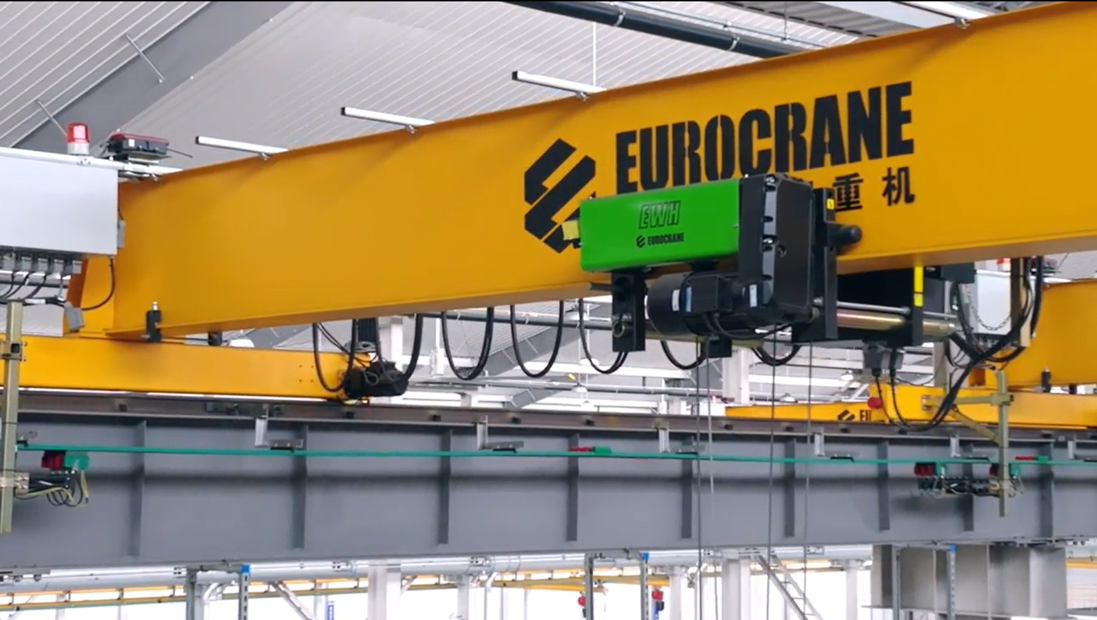 Eurocrane double girder overhead bridge crane executing lifting task on heavy industrial machinery final assembly line