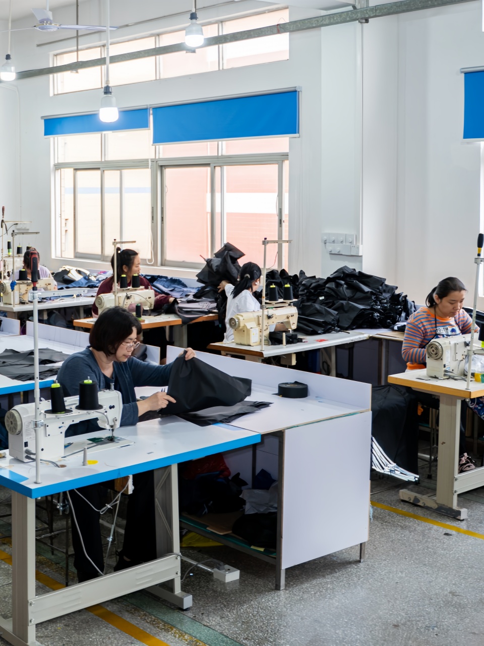 Worker-sewing-triangular-umbrella-panels-on-industrial-sewing-machine