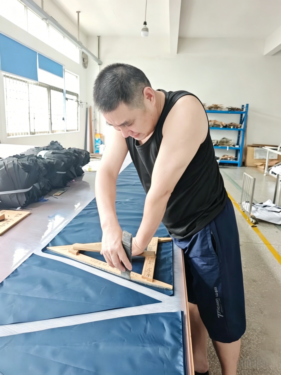 Worker-manually-cutting-umbrella-fabric-panels-on-cutting-table
