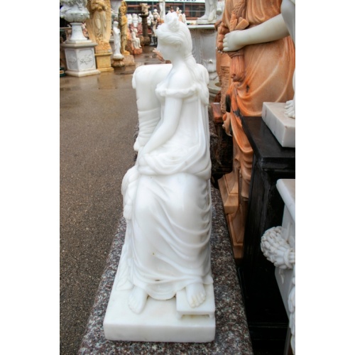 Elegante dama descansando sobre escultura de sofá de mármol