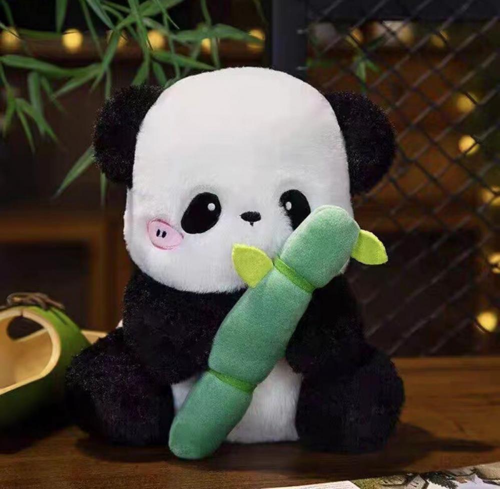 I panda giganti mangiano animali di peluche di bambù