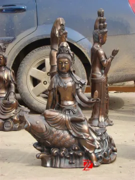bronze kwan yin statue sitting on fish sculpture