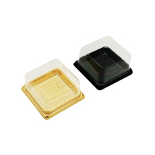 Quadratische schwarze goldene Plastikkuchenbox