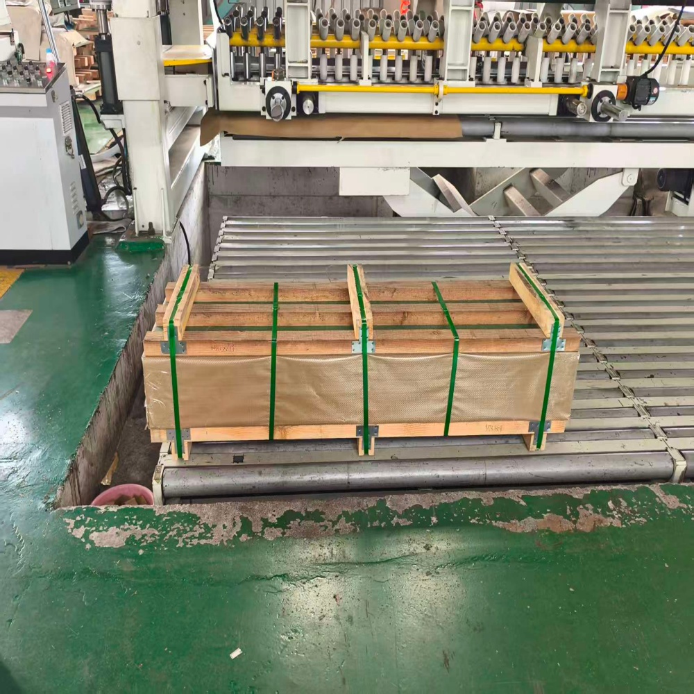 Packaged steel coils on conveyor belt in production line.