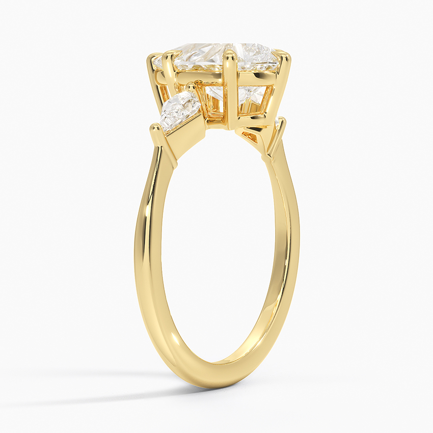 Angled na profile ng gold pear at trilyong brilyante na singsing na nagpapakita ng secure na gallery at prong structures