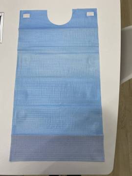 Disposable adult paper bib with pocket and adhesive