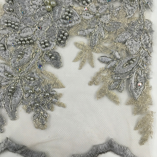 Broderie multicolore avec perle sur tissu en maille poly