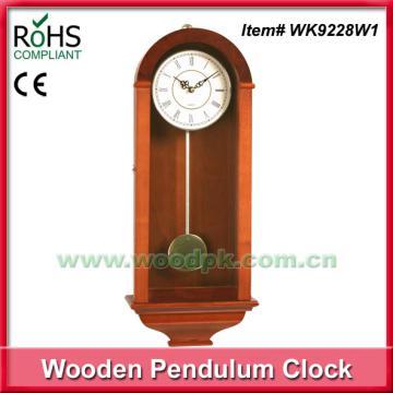 Wooden wall clock with revolving pendulum