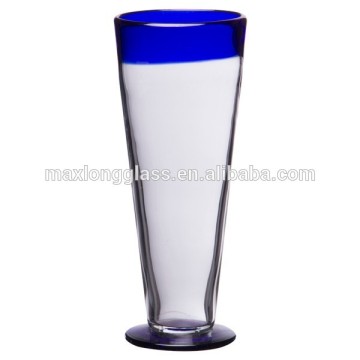Rustic beer glass and blue rim.