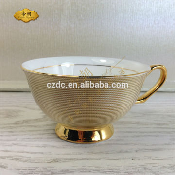 golden ceramic tea cup and saucer