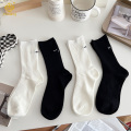 韓国の刺繍のまつげ女性の黒と白の積み重ねられた靴下