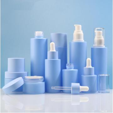 Barattolo di crema cosmetici blu e bottiglie di lozione