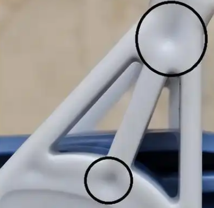 What causes shrinkage cavities in plastic injection molded parts?