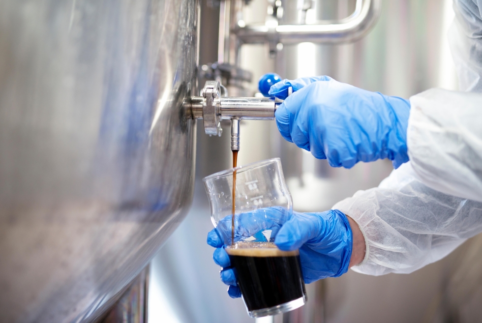 close-up-beer-filling-glass-brewery-quality-control-by-technologist