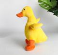 Gelbe Ente kauert Plüschhundspielzeug mit Geräusch